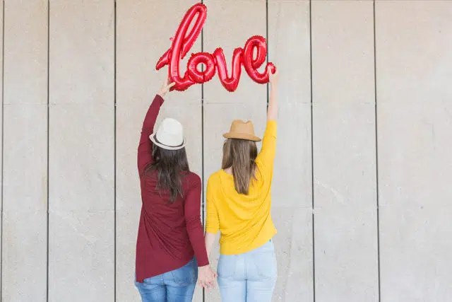 two beautiful young women having fun outdoors with a red balloon site de rencontre LGBT