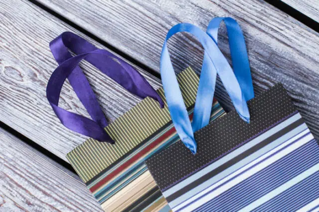 Beautiful gift bags on wooden background.