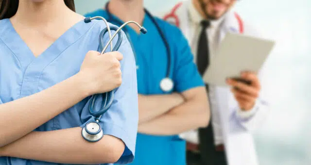 Doctor working in hospital with other doctors.