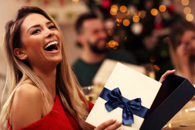 88070687 - group of friends giving christmas presents at home