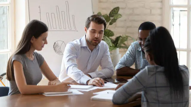 Diverse corporate clients and company chief during negotiations indoors