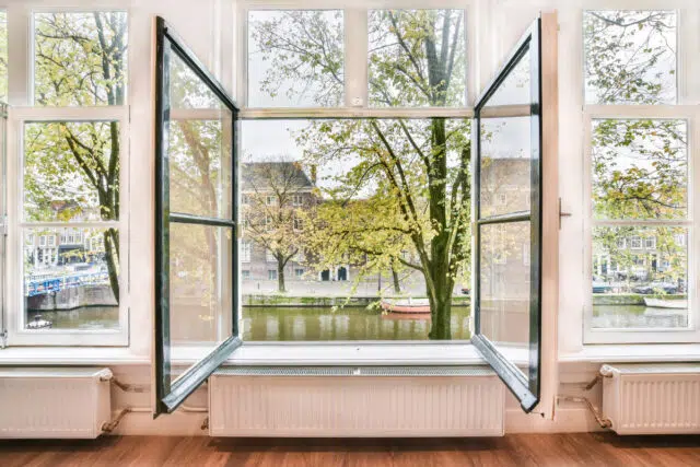 Open window with a view of the canal with trees traitement humidité