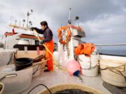 Fisherman hosing down fishing boat
