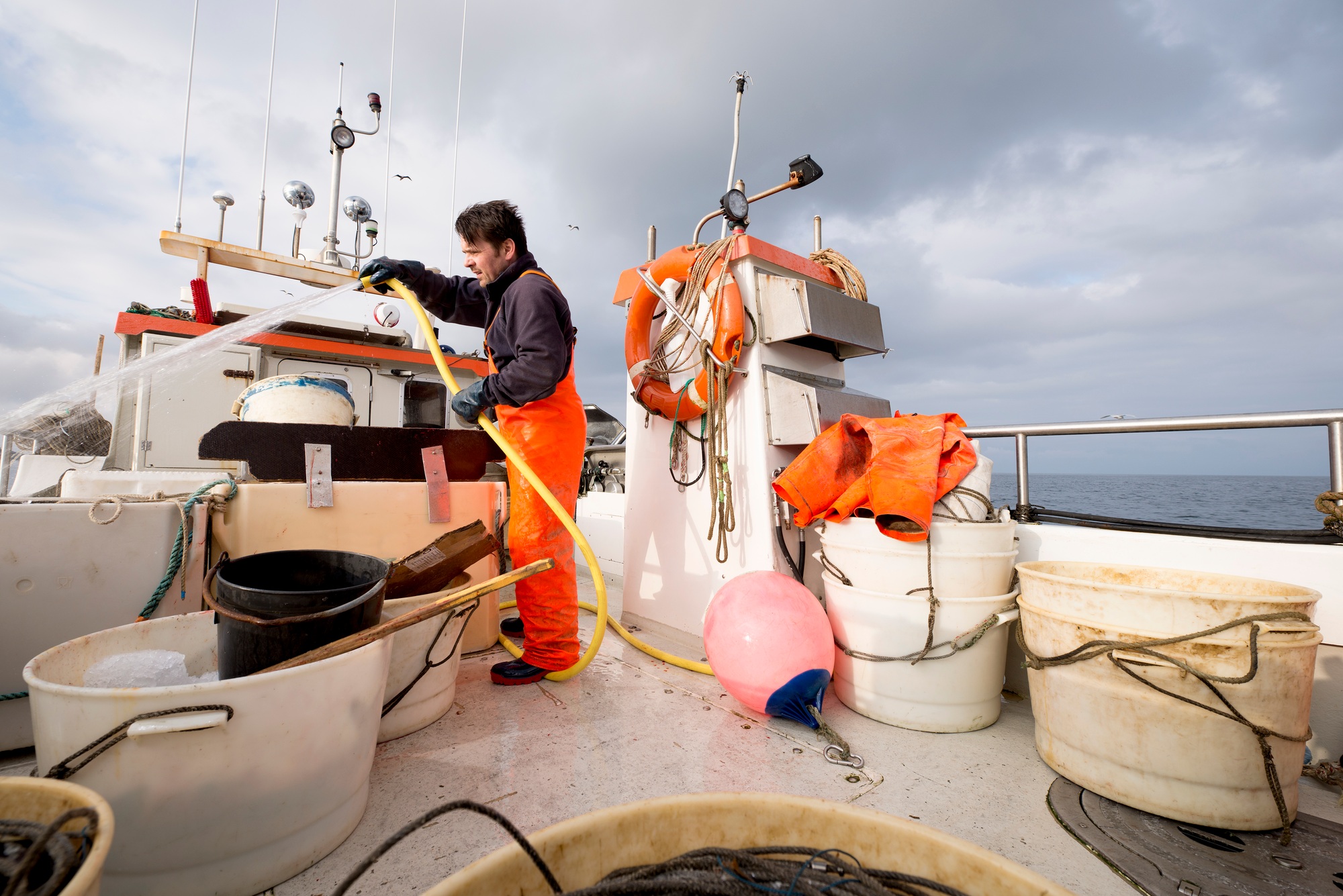 Fisherman hosing down fishing boat