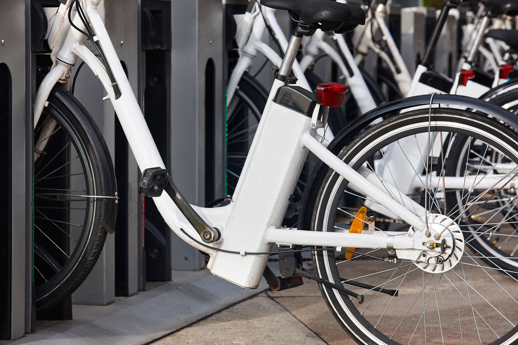 Urban electric bikes charging batteries in the city. To rent