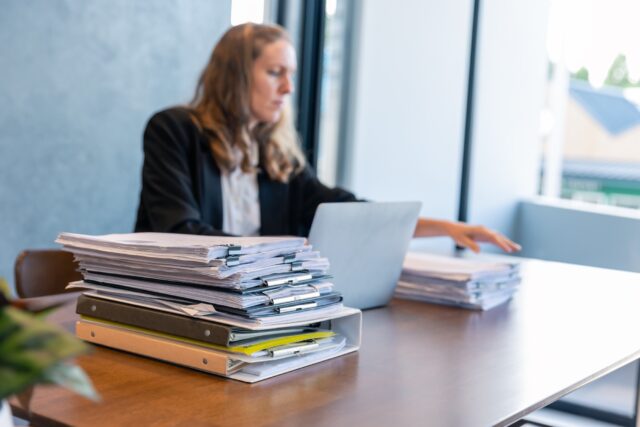 Businesswoman Working with Stacks of Documents Businesswoman Working with Stacks of Documents