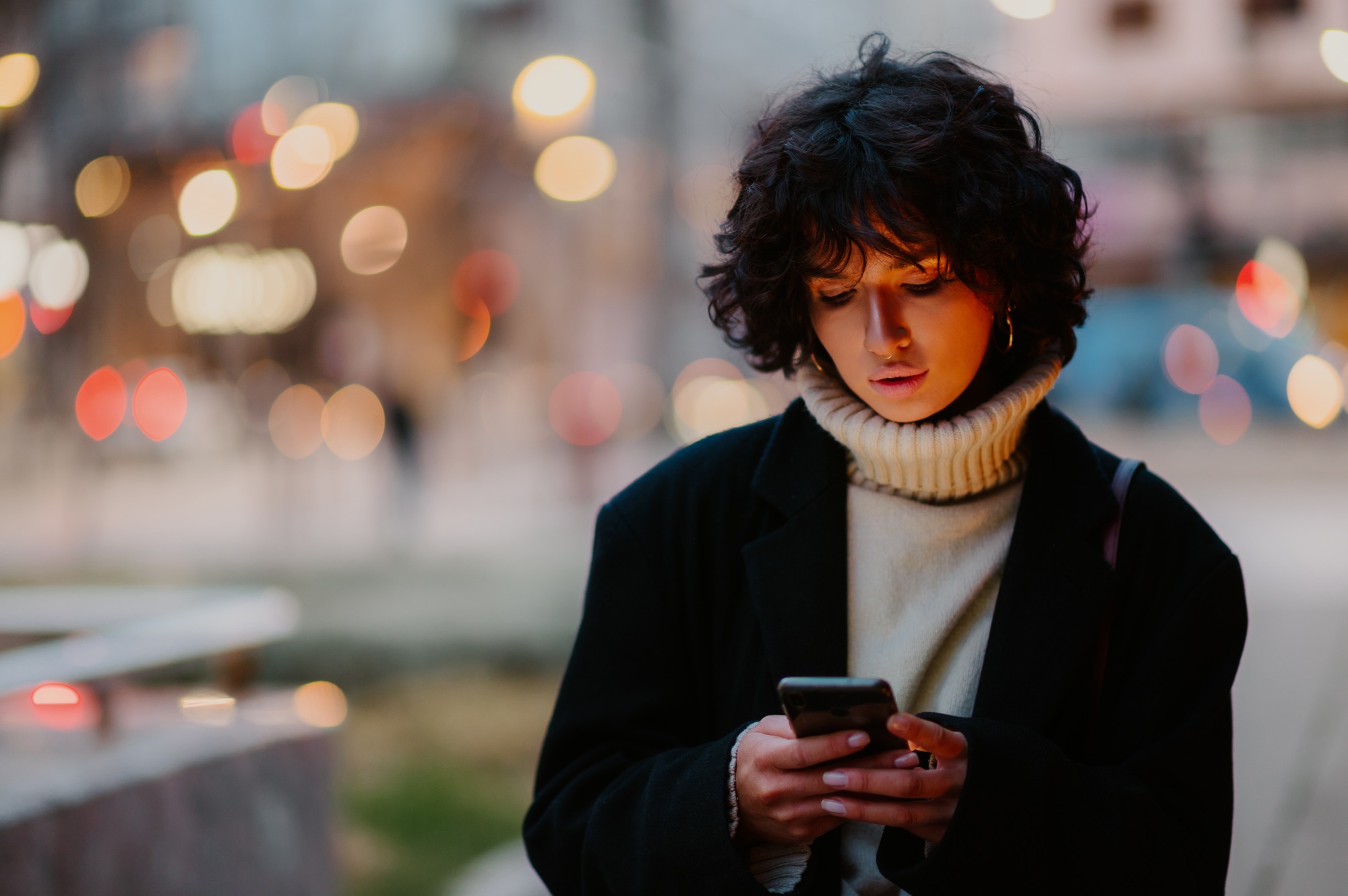 Caucasian girl looking down while sending a text message on her mobile phone.