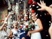 Family throwing rose petals at the newly wed bride and groom