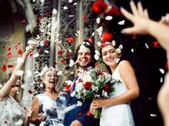 Family throwing rose petals at the newly wed bride and groom