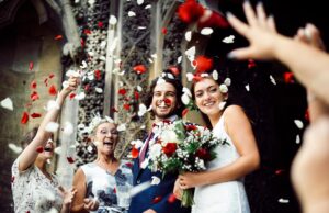 Family throwing rose petals at the newly wed bride and groom