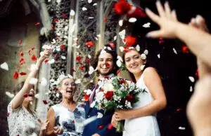 Family throwing rose petals at the newly wed bride and groom
