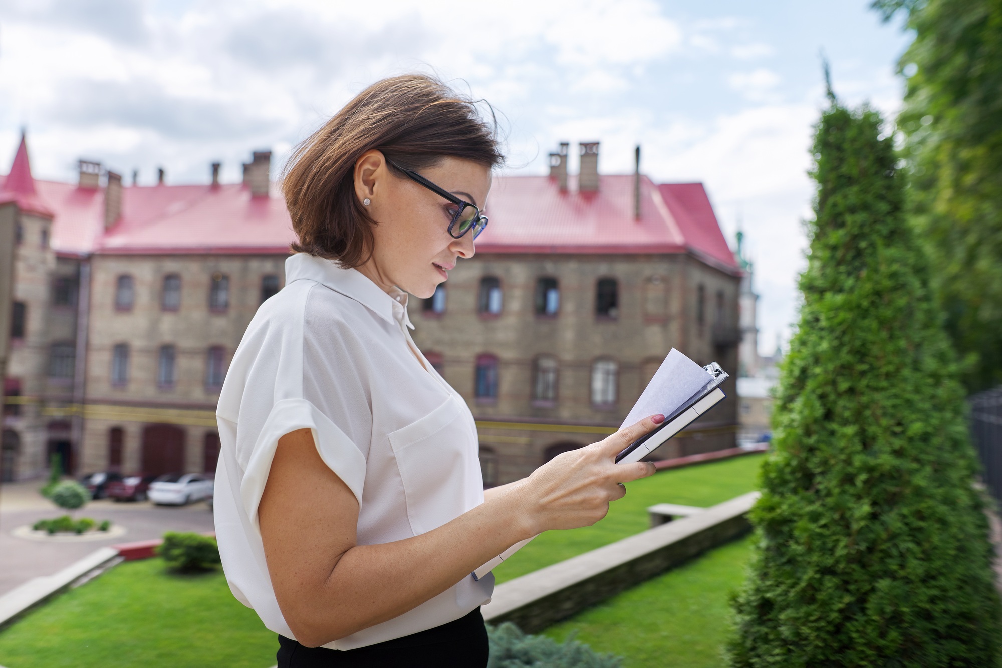 Portrait of mature businesswoman teacher with business papers documents