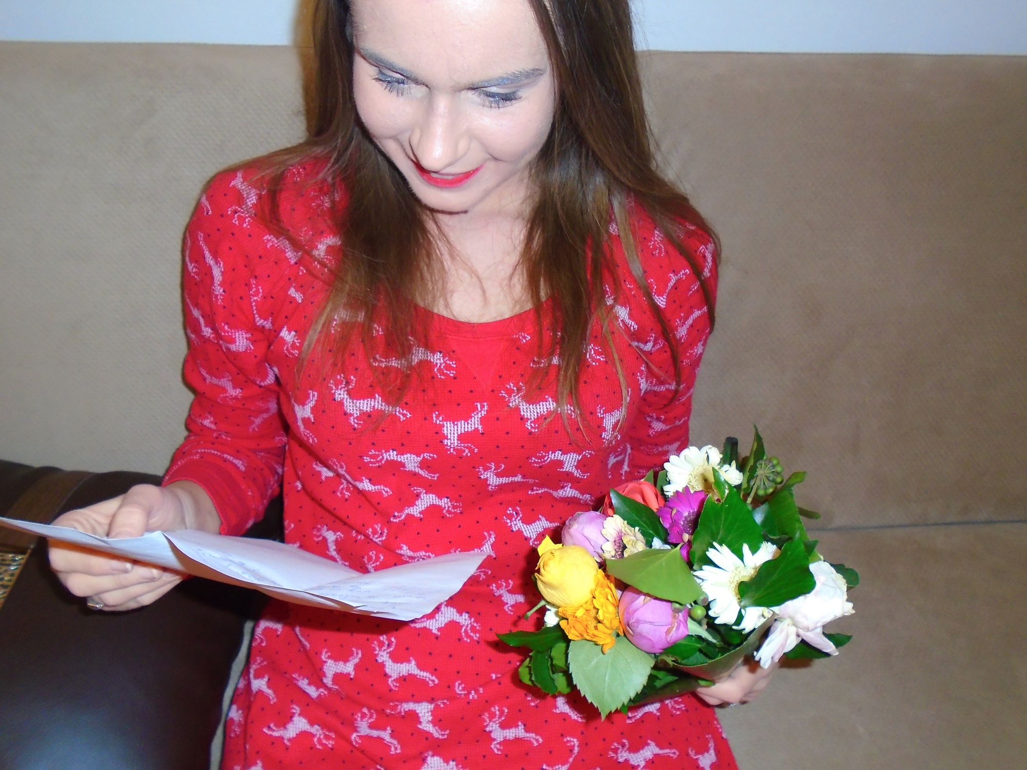 Woman holding a bouquet of flowers and reading a love letter