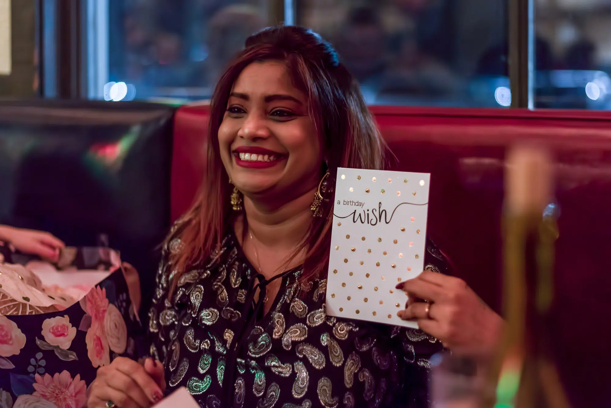 Beautiful young Indian woman smiling and holding a birthday card