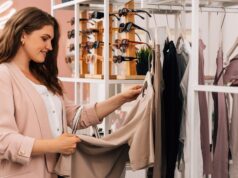 Side view of a smiling plus size woman shopping in a small clothing store