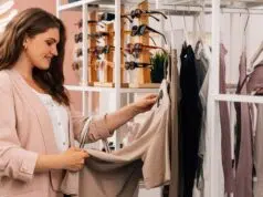 Side view of a smiling plus size woman shopping in a small clothing store