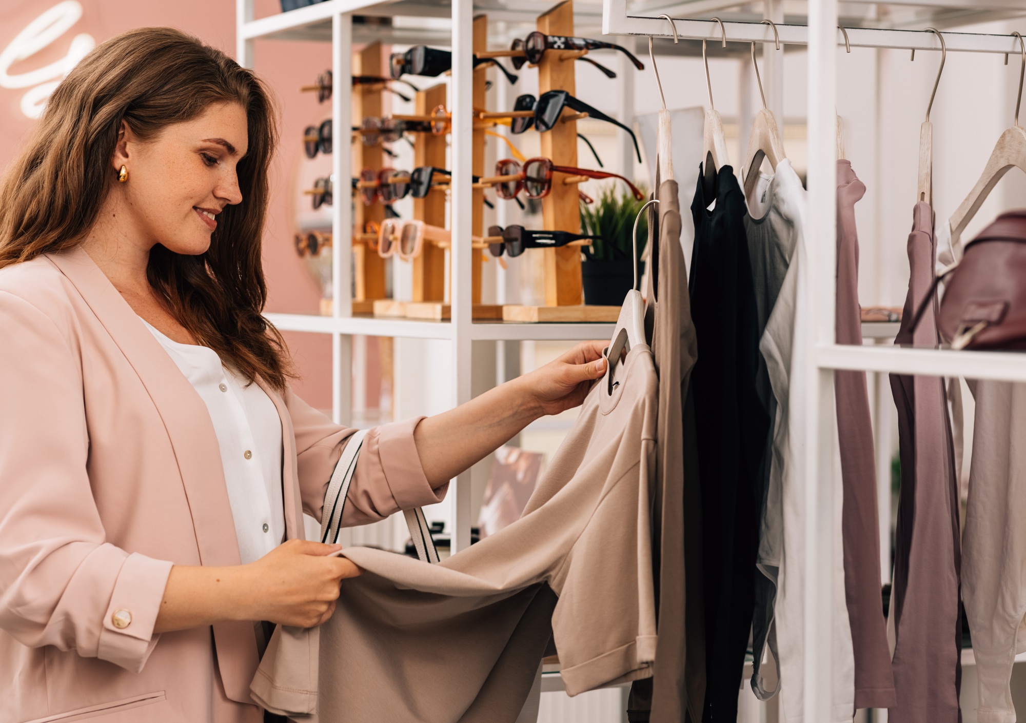 Side view of a smiling plus size woman shopping in a small clothing store
