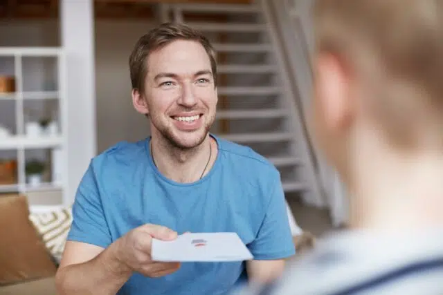 Smiling father giving birthday card to son Smiling father giving birthday card to son